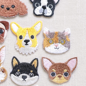 May include: A set of 14 embroidered iron-on patches featuring various animal faces, including a cat, dog, panda, rabbit, and more. The patches are perfect for adding a touch of whimsy to clothing, bags, or other fabric items.