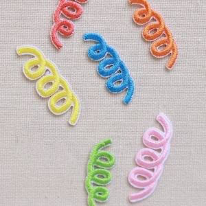 Puede incluir: Un conjunto de parches bordados con forma de espirales coloridas. Los parches son de color rojo, naranja, amarillo, azul, verde y rosa, cada uno con un borde blanco. Ideales para añadir un toque decorativo a la ropa o accesorios.