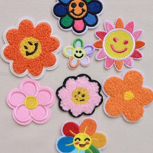 Puede incluir: Un conjunto de nueve parches bordados para planchar que presentan diseños de flores coloridas con caras sonrientes. Los parches son perfectos para agregar un toque divertido y caprichoso a la ropa, las bolsas u otros accesorios.