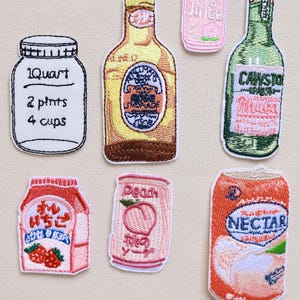 Puede incluir: Conjunto de parches bordados para planchar con diferentes bebidas, incluyendo un vaso de jugo, una botella de limonada, una botella de agua con gas, una lata de soda de melocotón, una caja de leche de fresa y una lata de néctar de melocotón. Los parches son todos en rosa, naranja, amarillo, verde y blanco.