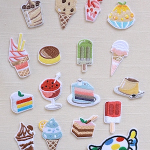 May include: A collection of embroidered patches featuring various desserts. Designs include ice cream cones, cake slices, popsicles, and a candy. The patches are colorful with detailed stitching, perfect for decorating clothing or accessories.