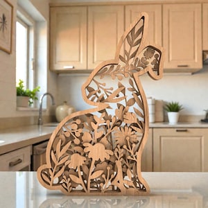 May include: A wooden Easter bunny decoration with a floral design. The bunny is cut out with intricate details, showcasing flowers and leaves. The natural wood color complements the detailed design, making it a charming addition to any home decor.