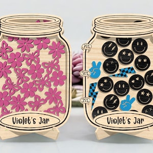 Può includere: Due pezzi decorativi in legno a forma di barattolo. Un barattolo è riempito di ritagli di fiori rosa, l'altro con faccine sorridenti nere, fulmini e simboli di pace. Entrambi i barattoli hanno il testo "Violet's Jar" e indicatori di percentuale.