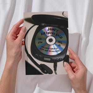 May include: A rectangular invitation card featuring a graphic of a black portable CD player with an open lid. The iridescent CD inside displays the text: Jame's Birthday Bash, Sat. 8pm, Aug. 25, 123 Check Check St, RSVP Amy 123.456.7890.