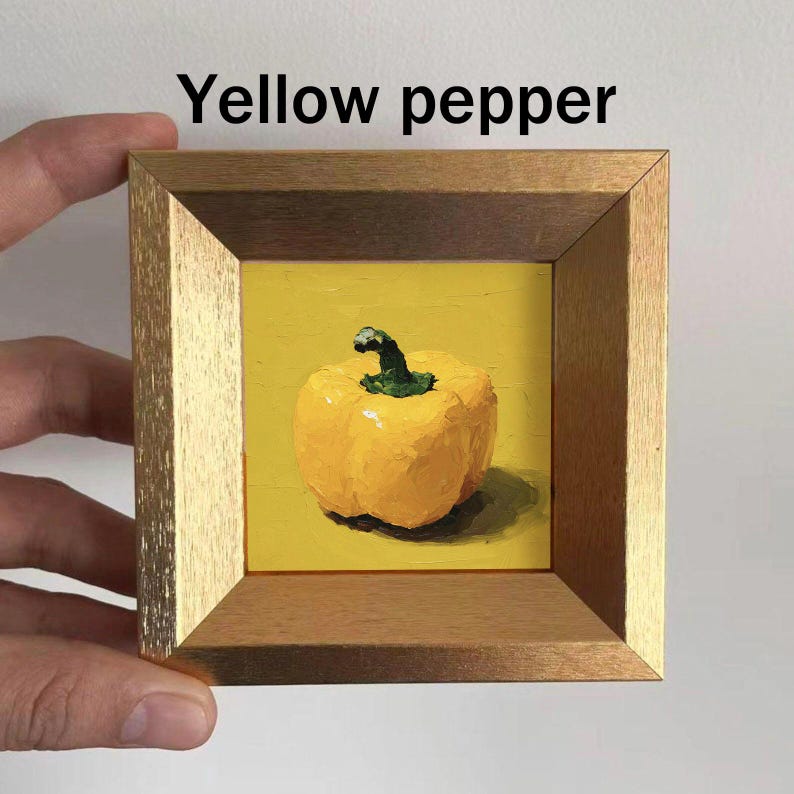 May include: A framed painting of a yellow bell pepper with a green stem. The artwork is set against a yellow background and is enclosed in a wooden frame. The text "Yellow pepper" is above the painting.