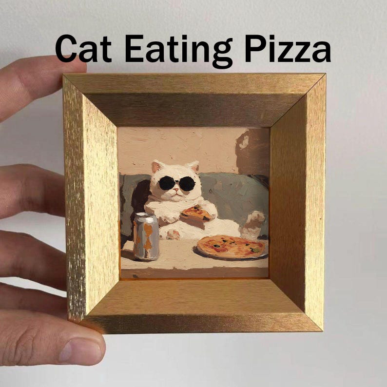 May include: A framed artwork featuring a white cat wearing sunglasses and eating pizza. The image includes a can of soda and a whole pizza. The text "Cat Eating Pizza" is displayed at the top of the frame. The frame is gold.