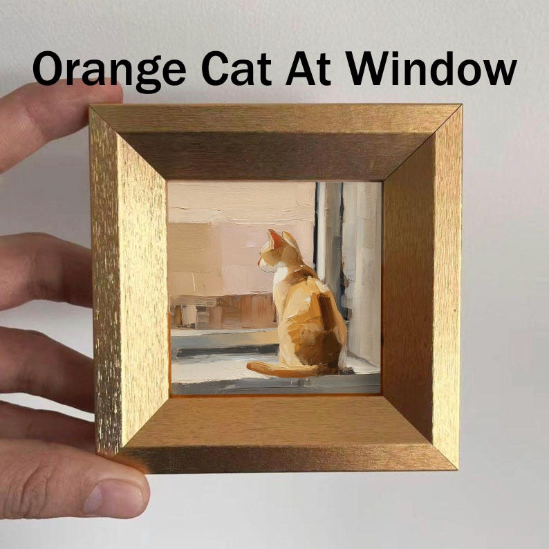 May include: A framed painting titled "Orange Cat At Window" depicts an orange and white cat gazing out a window. The artwork is set within a gold-colored wooden frame. The painting's style is impressionistic, with visible brushstrokes.