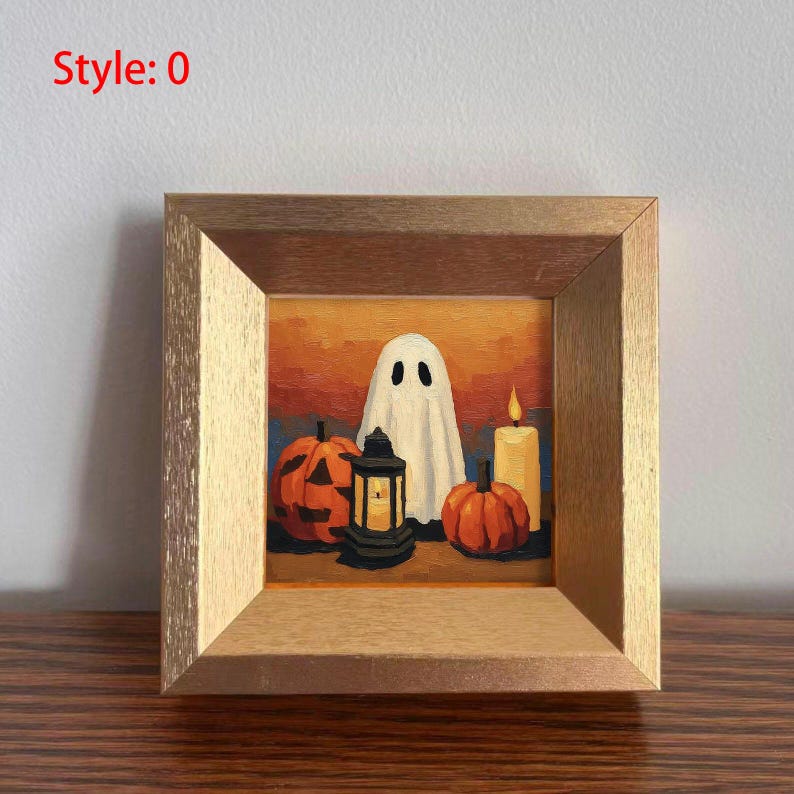 May include: A framed painting with a Halloween theme. The artwork depicts a white ghost, two carved pumpkins, a lit candle, and a lantern. The background has orange and blue tones. The frame is made of light-coloured wood. The text "Style: 0" is in the upper left corner.