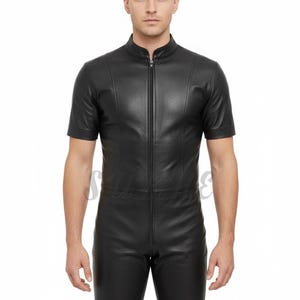 May include: Black leather jumpsuit with short sleeves and shorts. The jumpsuit features a high collar and a full-length zipper down the front. The garment is form-fitting and made of a shiny, smooth material.