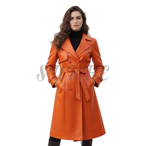 May include: An orange trench coat with a double-breasted design, a belt, and pockets. The coat is knee-length and has long sleeves. The model is wearing a black turtleneck underneath.