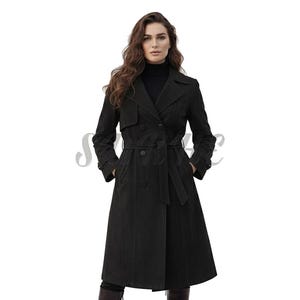 May include: A black trench coat with a double-breasted design, a belt, and pockets. The coat has a classic silhouette with a notched collar and long sleeves. The model is wearing a black turtleneck underneath.