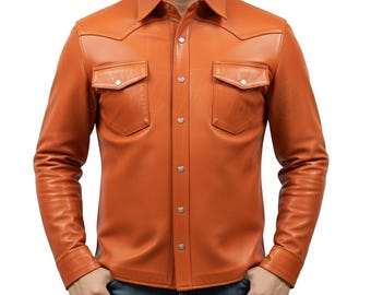 May include: An orange leather shirt with two chest pockets and silver snap closures. The long-sleeved shirt has a classic collar and a Western-style yoke design. The model is wearing blue jeans.