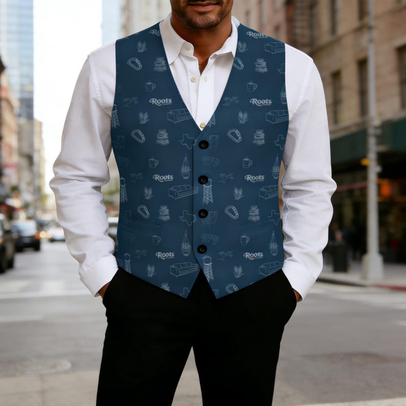May include: A navy blue vest with a white pattern of various icons, including a sofa, a coffee cup, and the word "Roots". The vest has a button-up front and is worn over a white dress shirt.