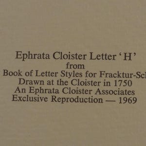 May include: Text on a beige background reads "Ephrata Cloister Letter 'H'" from "ABC Book of Letter Styles for Fracktur-Schriften" drawn in 1750. It is an exclusive reproduction from 1969 by Ephrata Cloister Associates.