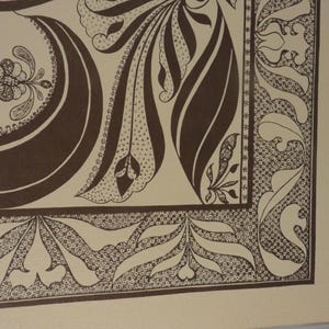 May include: Close-up of a decorative artwork featuring a repeating pattern of brown floral and leaf motifs on a beige background. The design includes intricate details and a border with stylized leaves and dots.