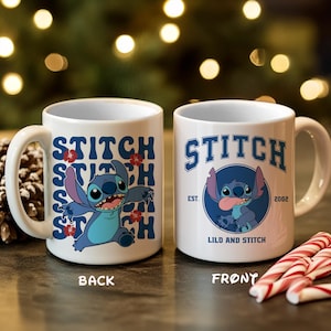 Puede incluir: Dos tazas de cer&aacute;mica blanca con el personaje Stitch de Lilo & Stitch. Una taza tiene la palabra "STITCH" apilada con una imagen de dibujos animados de Stitch. La otra taza tiene un gr&aacute;fico de Stitch con el texto "LILO AND STITCH".