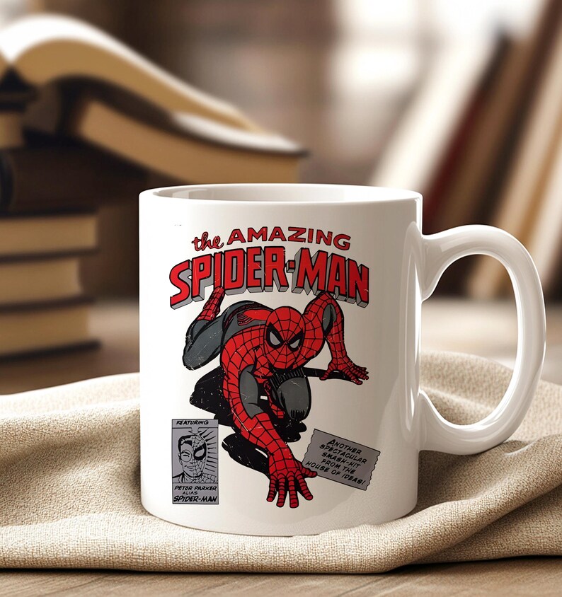 May include: White ceramic mug featuring a comic book illustration of Spider-Man in red and black. The mug has the text "the AMAZING SPIDER-MAN" in red and white. Additional text includes "FEATURING PETER PARKER SPIDER-MAN".