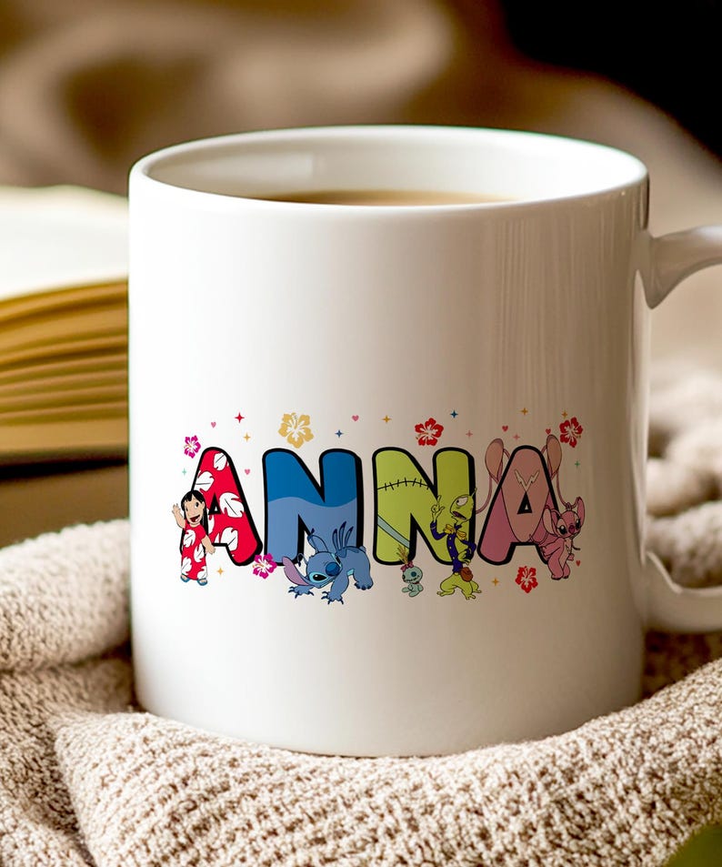 May include: White ceramic mug featuring the name "ANNA" in colorful, cartoon-style letters. Each letter is decorated with a different character from a popular animated series, with floral accents.