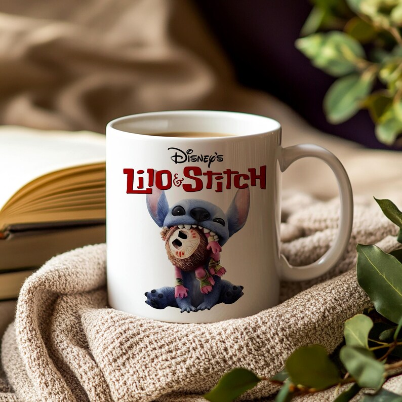 K&ouml;nnte beinhalten: Wei&szlig;e Keramik-Tasse mit Disney's Lilo & Stitch. Die Tasse zeigt Stitch, der eine Puppe h&auml;lt, mit dem Disney's Lilo & Stitch-Logo in Rot. Die Tasse hat einen gebogenen Griff und steht vor einem neutralen Hintergrund.