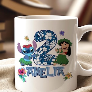 May include: White ceramic mug with a design featuring the number 2 in a blue floral pattern, Stitch and Lilo characters, and the name "AMELIA" in blue. The mug has a white handle and is decorated with colourful flowers.