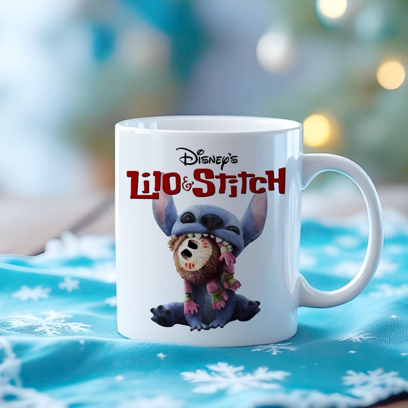 K&ouml;nnte beinhalten: Wei&szlig;e Keramik-Tasse mit Disney's Lilo & Stitch. Die Tasse zeigt Stitch, einen blauen Au&szlig;erirdischen, der ein braunes Objekt im Mund h&auml;lt. Die Tasse hat einen wei&szlig;en Henkel und das Disney's Lilo & Stitch-Logo in Rot.