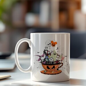 May include: White ceramic mug featuring a Halloween-themed design. The design includes characters from The Nightmare Before Christmas, inside an orange teacup with a jack-o'-lantern face. Black bats and spiderwebs are also included in the design.