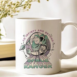 May include: White ceramic mug with a cartoon illustration of a space ranger. The mug has the text "TO INFINITY AND BEYOND" and "SPACE RANGER". The design features a space ranger in a green and white spacesuit, a planet, and stars.