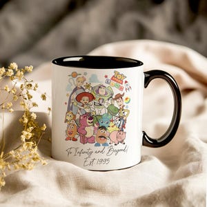 Pu&ograve; includere: Tazza in ceramica bianca con bordo e manico neri. La tazza presenta un'illustrazione colorata di personaggi del franchise Toy Story, tra cui Woody, Buzz Lightyear e Jessie. Il testo "Toy Story Land" e "To Infinity and Beyond! Est. 1995" &egrave; stampato sulla tazza.