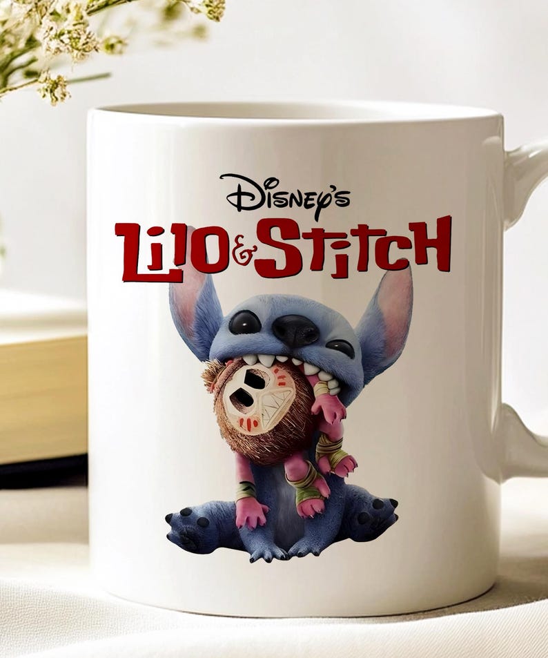 K&ouml;nnte beinhalten: Wei&szlig;er Keramikbecher mit Disney's Lilo & Stitch. Der Becher zeigt Stitch, einen blauen Au&szlig;erirdischen, der eine Puppe h&auml;lt. Der Becher hat das Disney's Lilo & Stitch-Logo in Rot. Der Becher hat einen wei&szlig;en Griff.