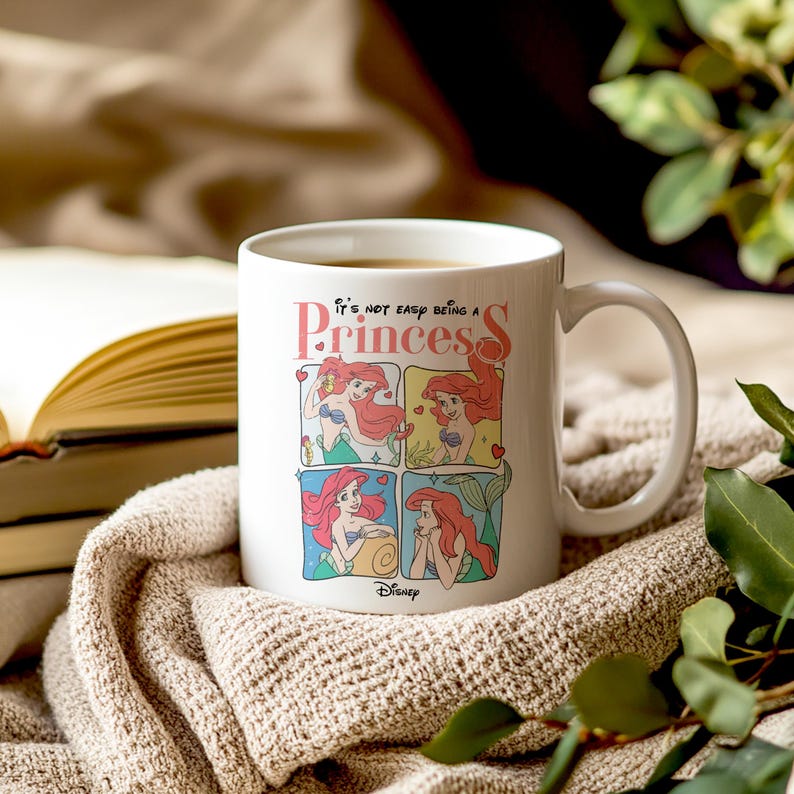 Pode incluir: Caneca de cer&acirc;mica branca com uma ilustra&ccedil;&atilde;o colorida de Ariel de A Pequena Sereia. A caneca tem o texto "N&atilde;o &eacute; f&aacute;cil ser uma princesa".