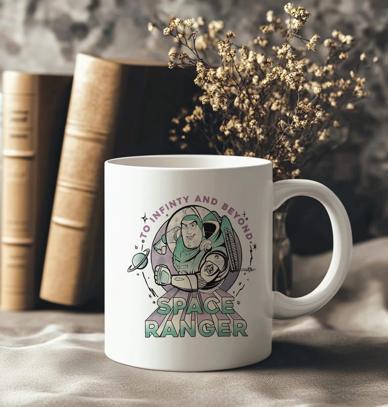 May include: White ceramic mug with a graphic of Buzz Lightyear in his space ranger suit, and the text "TO INFINITY AND BEYOND" and "SPACE RANGER". The mug has a curved handle. The background is neutral.