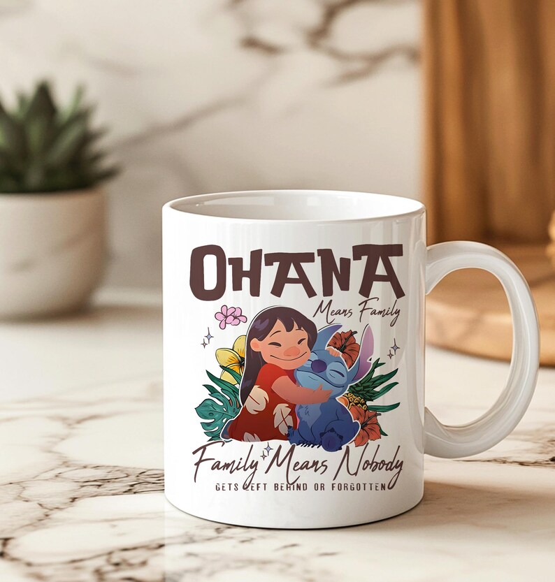 May include: White ceramic mug with a colourful illustration of Lilo and Stitch embracing, and the text "Ohana Means Family" and "Family Means Nobody Gets Left Behind or Forgotten". The mug has a curved handle.