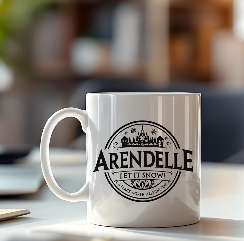 May include: White ceramic mug with a curved handle. The mug features a black circular design with the word "ARENDELLE" in bold letters, along with the phrase "LET IT SNOW!" and a winter landscape illustration. The phrase "A PLACE WORTH MELTING FOR" is also included.