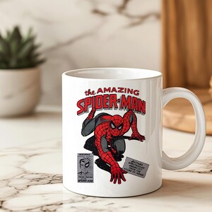 May include: White ceramic mug featuring a comic book illustration of Spider-Man in a red and black suit. The mug has the text "the AMAZING SPIDER-MAN" in red and black lettering. Additional text includes "FEATURING" and "PETER PARKER SPIDER-MAN".