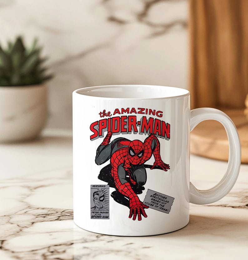 May include: White ceramic mug featuring a comic book illustration of Spider-Man in a red and black suit. The mug has the text "the AMAZING SPIDER-MAN" in red and black lettering. Additional text includes "FEATURING" and "PETER PARKER SPIDER-MAN".