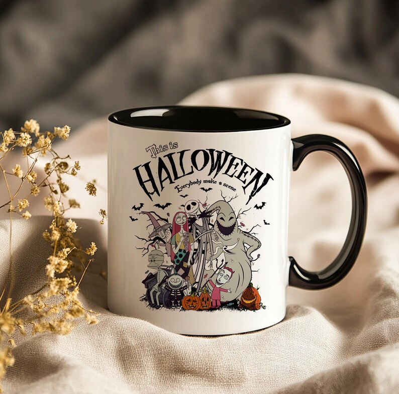 May include: White ceramic mug with a black interior and handle. The mug features a Halloween-themed design with characters and the text "This is Halloween." Bats and pumpkins are also included in the design.