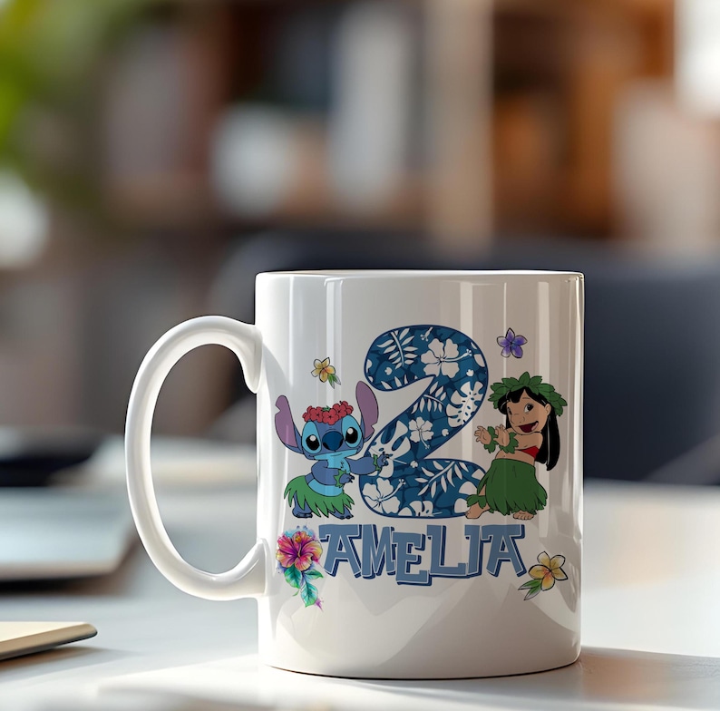 May include: White ceramic mug with a design featuring the number "2" in a blue floral pattern, Stitch, Lilo, and the name "AMELIA". The mug has a curved handle and is decorated with tropical flowers.