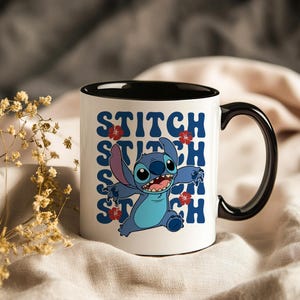Puede incluir: Taza de cer&aacute;mica blanca con interior y asa negros. La taza presenta un personaje de dibujos animados azul, la palabra "STITCH" en azul y detalles de flores rojas. El dise&ntilde;o se repite verticalmente en la taza.