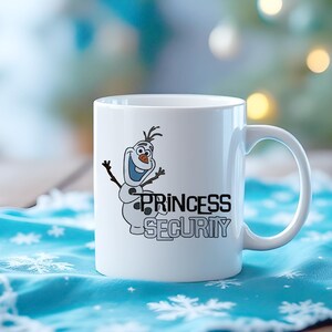 May include: White ceramic mug featuring a cartoon Olaf snowman character with the text "PRINCESS SECURITY" in black and gray. The mug has a curved handle and is set on a blue snowflake-patterned cloth.