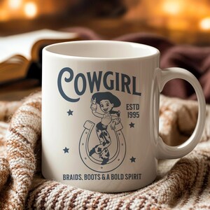 Pu&ograve; includere: Tazza in ceramica bianca con un design da cowgirl. La tazza presenta la parola "Cowgirl", un'illustrazione di cowgirl dei cartoni animati e il testo "Braids, Boots & A Bold Spirit". La tazza ha anche il testo "ESTD 1995" e stelle.