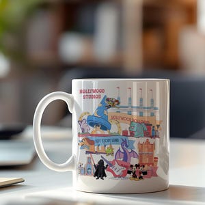 K&ouml;nnte beinhalten: Wei&szlig;er Keramikbecher mit einer farbenfrohen Illustration von Hollywood Studios Attraktionen und Charakteren. Der Becher tr&auml;gt die Aufschrift "Hollywood Studios" und "Toy Story Land". Das Design umfasst einen blauen Zaubererhut, einen Drachen sowie Micky und Minnie Maus.