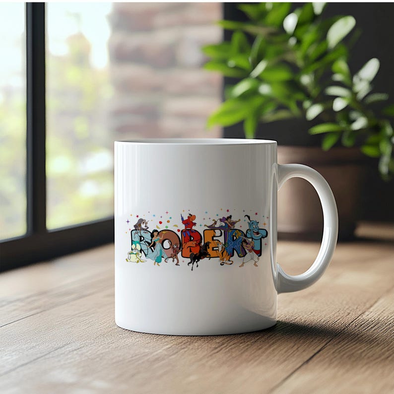 May include: White ceramic mug with the name "ROBERT" in colorful, cartoon-style letters. Each letter is decorated with different cartoon characters. The mug has a curved handle and is set on a wooden surface.