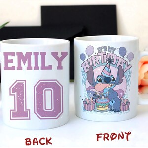 May include: White ceramic mug with a handle, featuring a design for a birthday celebration. The front of the mug has a cartoon character with the text "IT'S MY BIRTHDAY". The back of the mug has the name "EMILY" and the number "10" in a purple color.