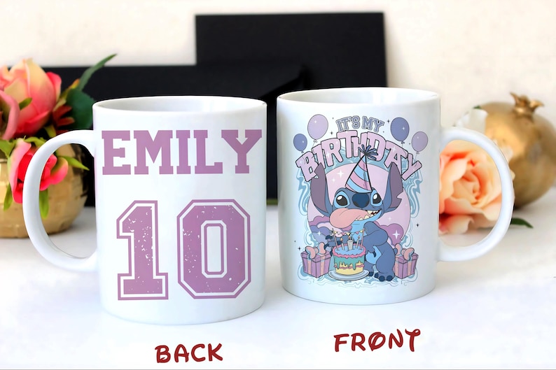 May include: White ceramic mug with a handle, featuring a design for a birthday celebration. The front of the mug has a cartoon character with the text "IT'S MY BIRTHDAY". The back of the mug has the name "EMILY" and the number "10" in a purple color.