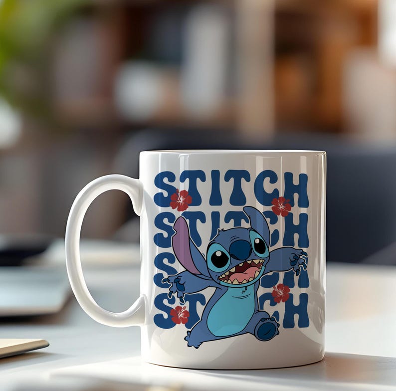 Puede incluir: Taza de cer&aacute;mica blanca con un personaje de dibujos animados azul con orejas grandes y la palabra "STITCH" en texto azul. Acentos de flores rojas est&aacute;n colocados en todo el dise&ntilde;o. La taza tiene un asa blanca y est&aacute; sobre un fondo borroso.
