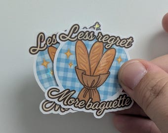 May include: A set of stickers with a blue gingham background and the text "Less regret, More baguette." The stickers feature illustrations of baguettes in a brown paper bag, with gold star accents.