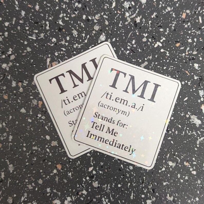 May include: Two white stickers with the acronym "TMI" in large, dark letters. The stickers also include the pronunciation and the phrase "Stands for: Tell Me Immediately."