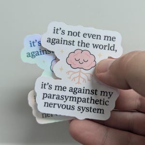 May include: A collection of stickers with a light background. The stickers have a cloud-like shape and feature the text "it's not even me against the world, it's me against my parasympathetic nervous system." A pink brain graphic is also present.