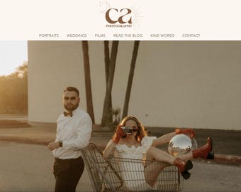 Puede incluir: Una pareja posa para una sesión de fotos en un estacionamiento. La mujer está sentada en un carrito de compras sosteniendo una bola de discoteca y el hombre está empujando el carrito. La pareja lleva ropa informal y el fondo es un día soleado.