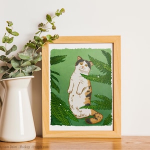 Peut inclure: Une illustration encadrée d'un chat tricolore debout sur ses pattes arrière, les pattes avant levées. Le chat est entouré de fougères vertes et a un fond blanc.